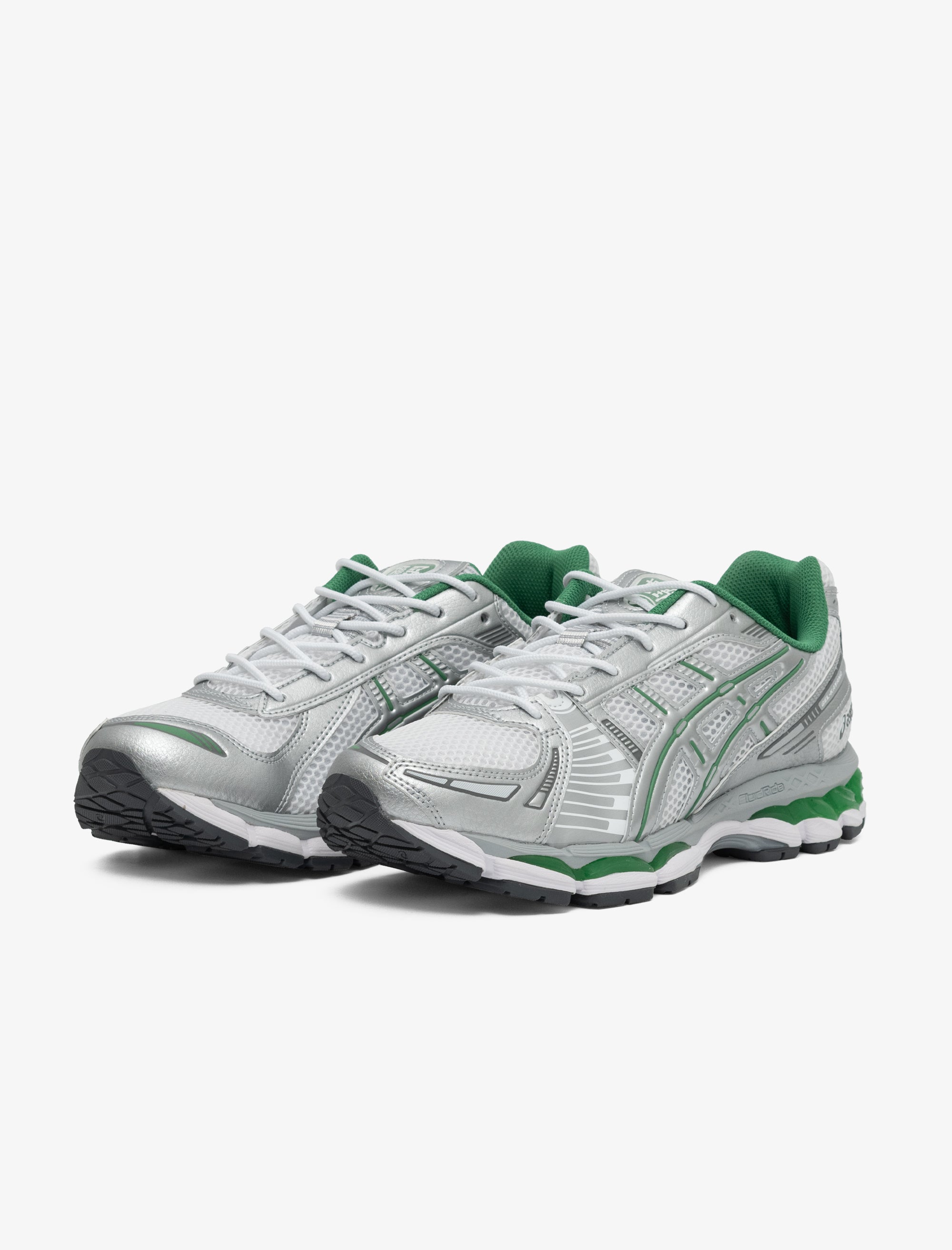 Pair of white running shoes with green accents on a white background