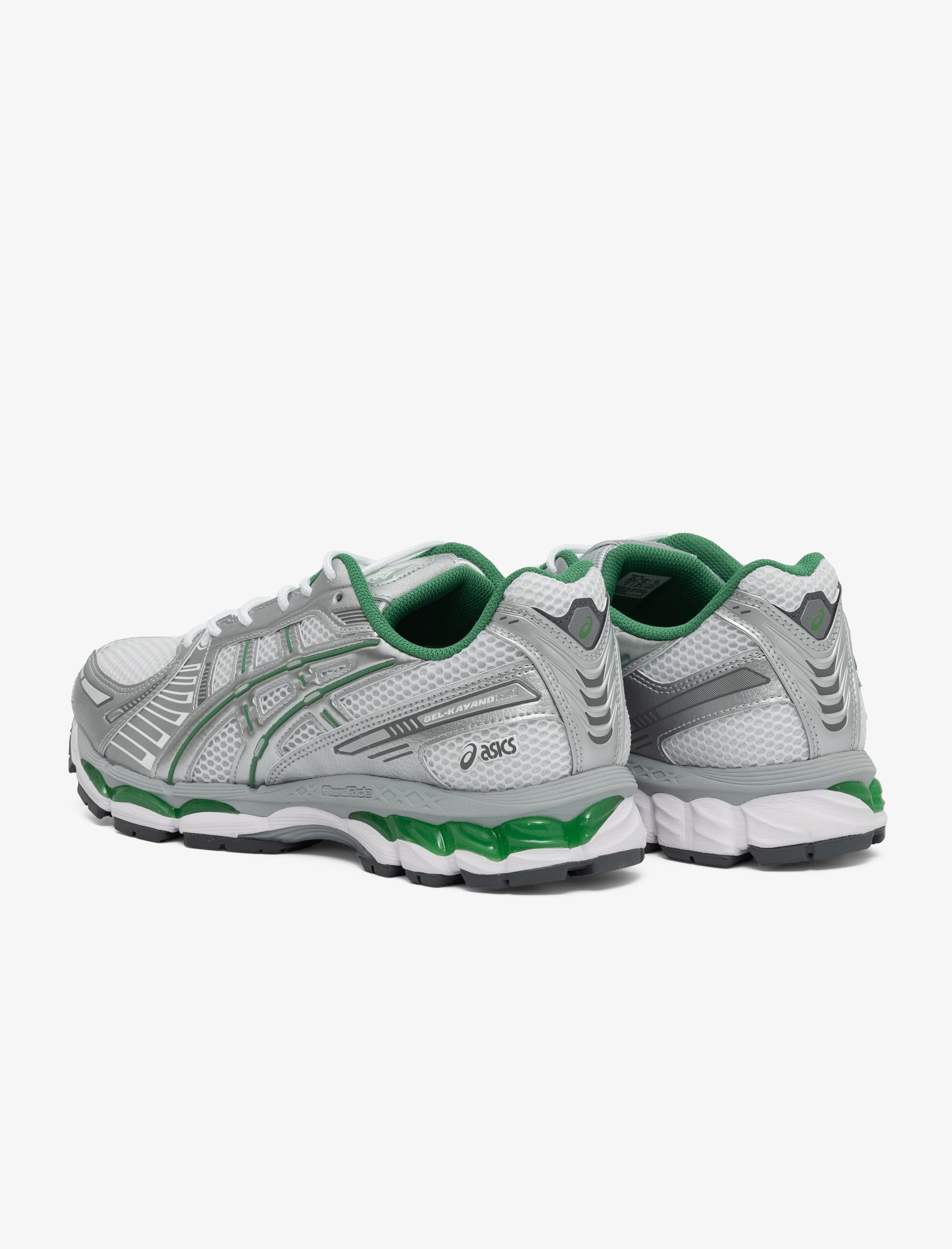 Gray and green running shoes on a white background