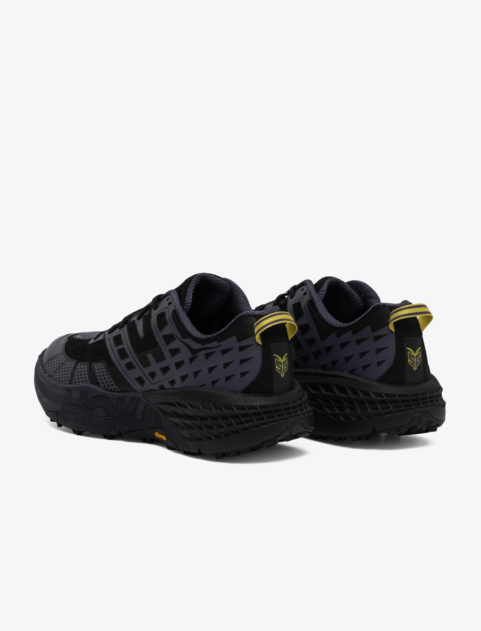 Black athletic shoes with yellow accents on a white background