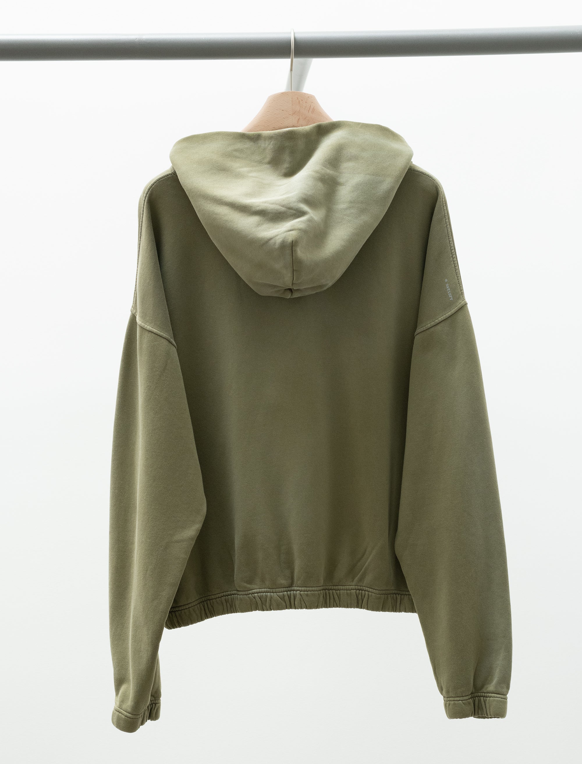 Green hoodie on a hanger against a white background