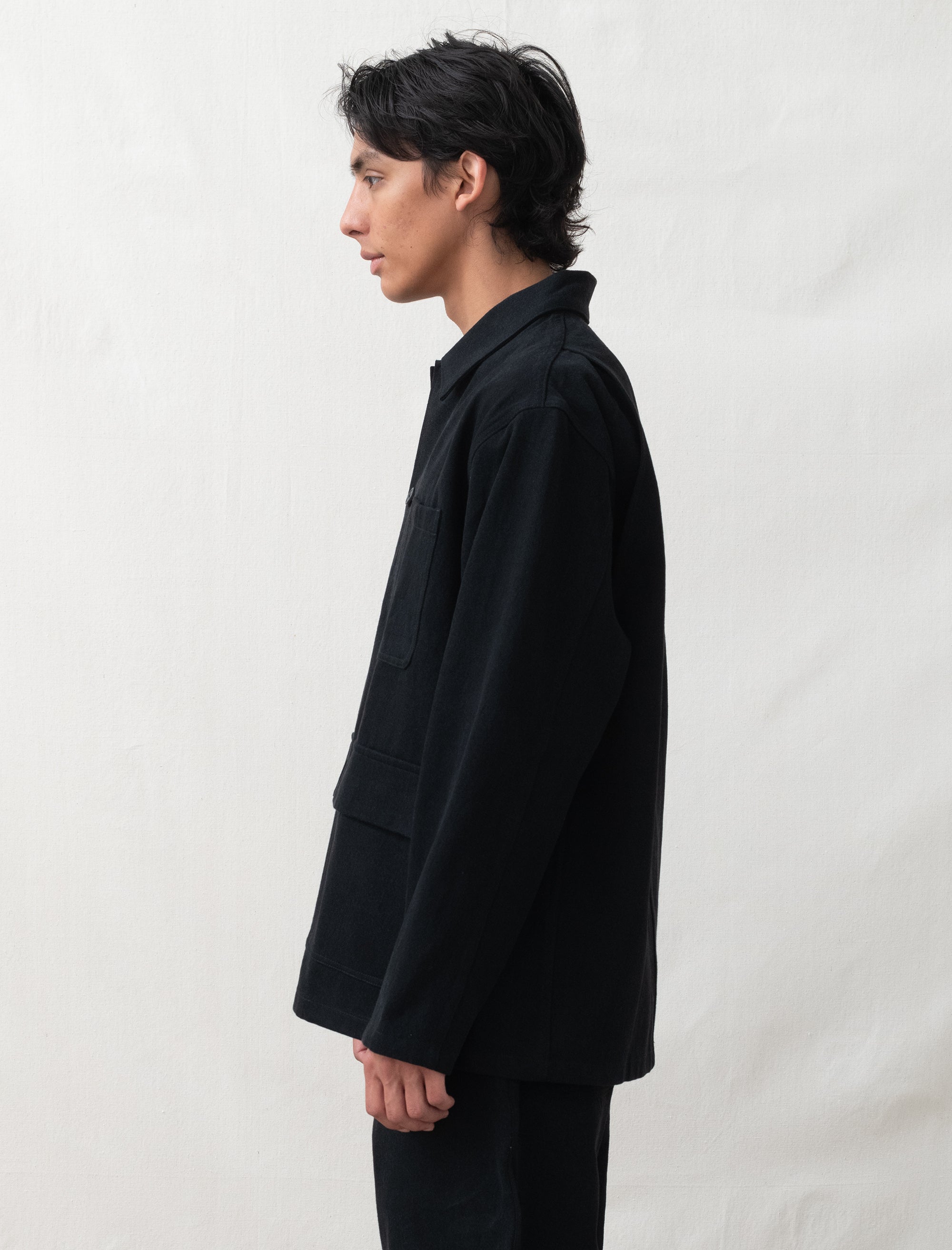 Person wearing a black jacket against a white background