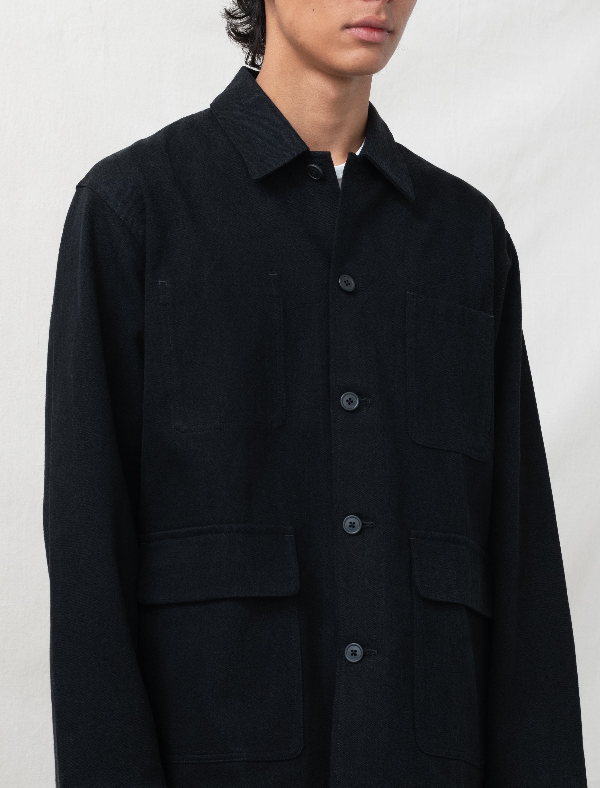 Black jacket worn by a person on a white background