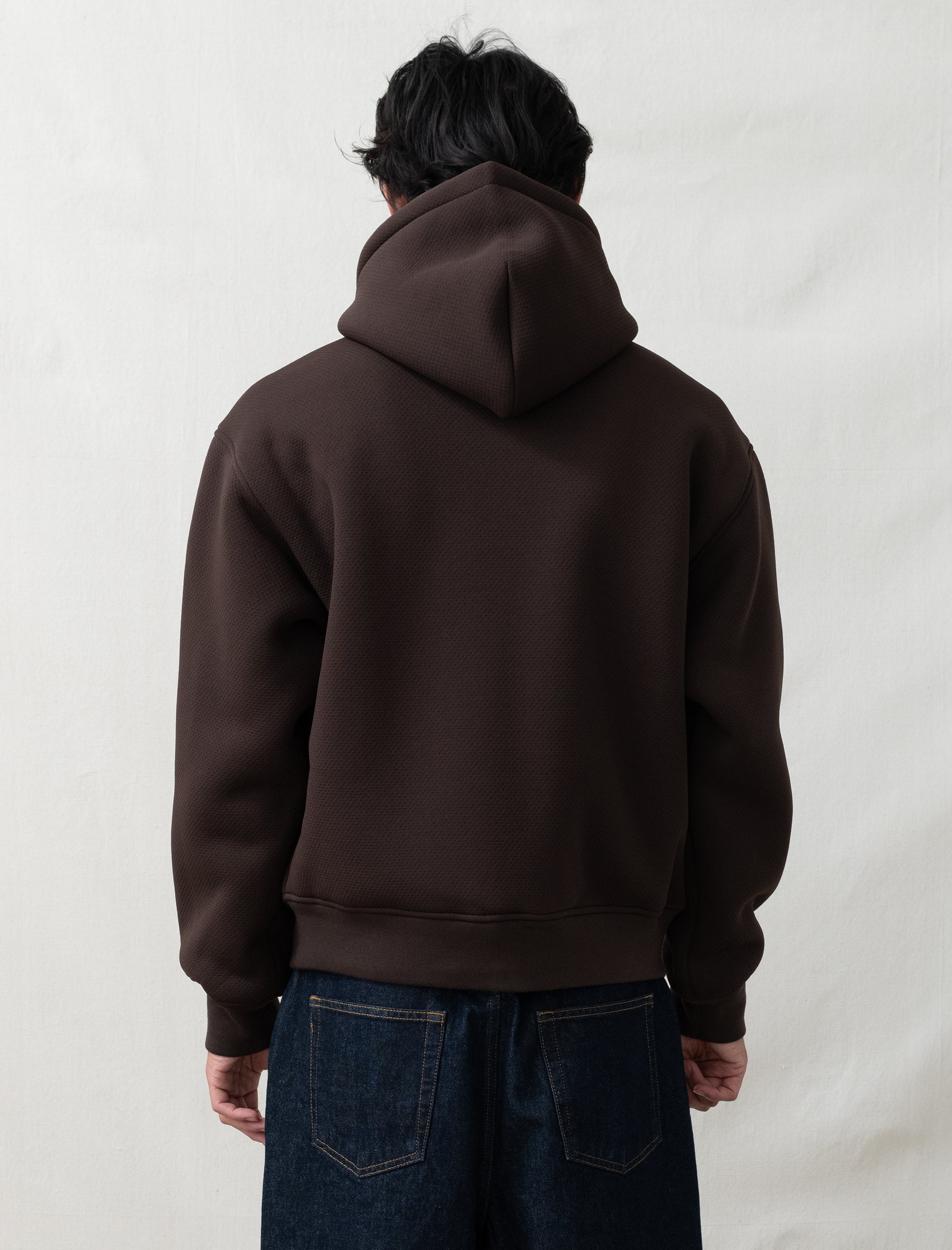 someone wearing a brown zip hoodie in front of a white background