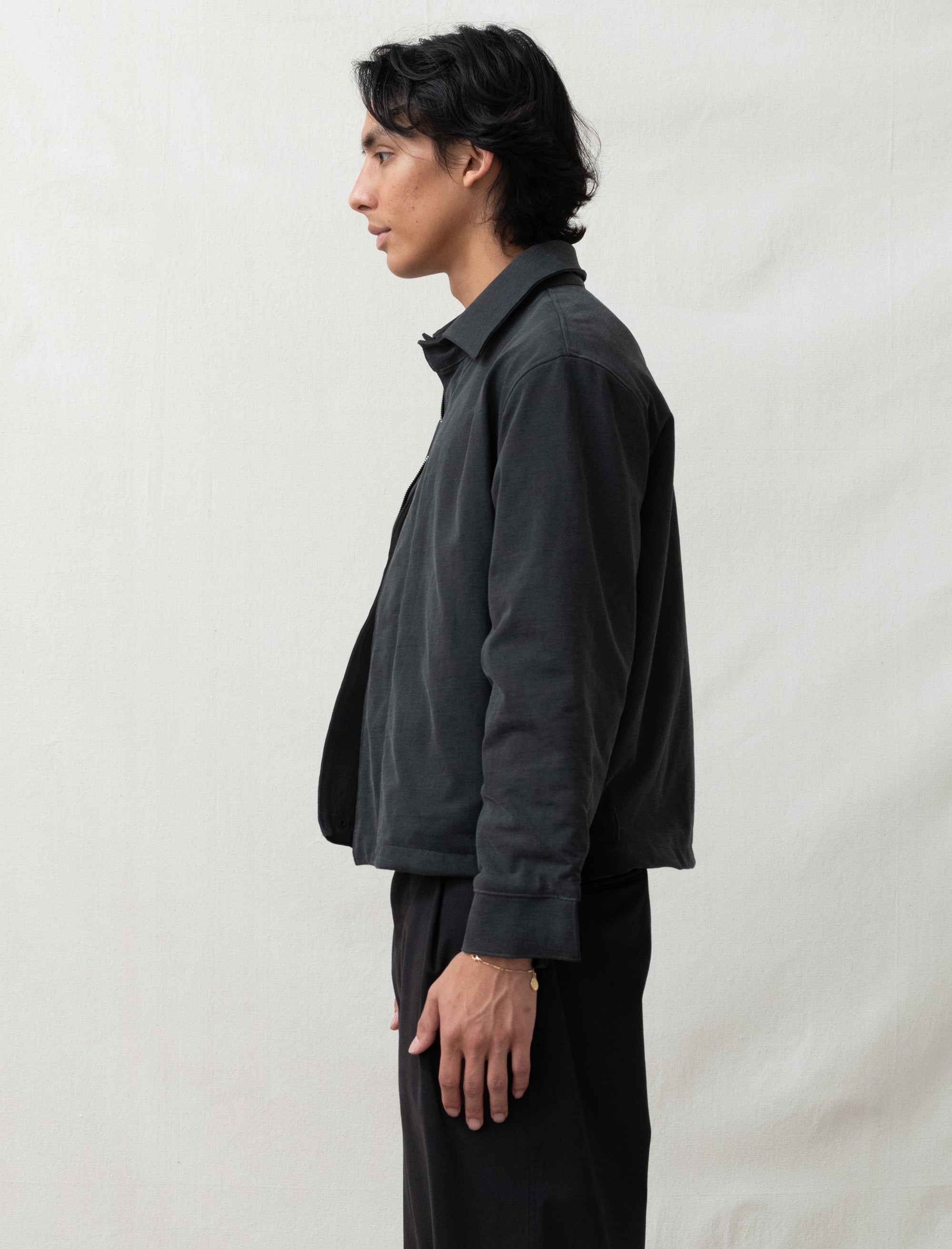 person wearing dark jacket in front of white background