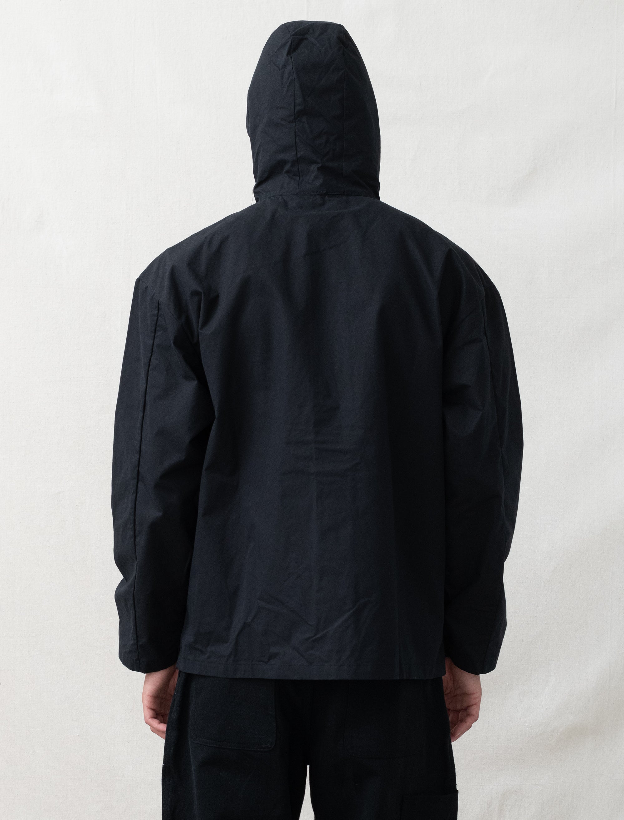 Person wearing a black raincoat on a white background