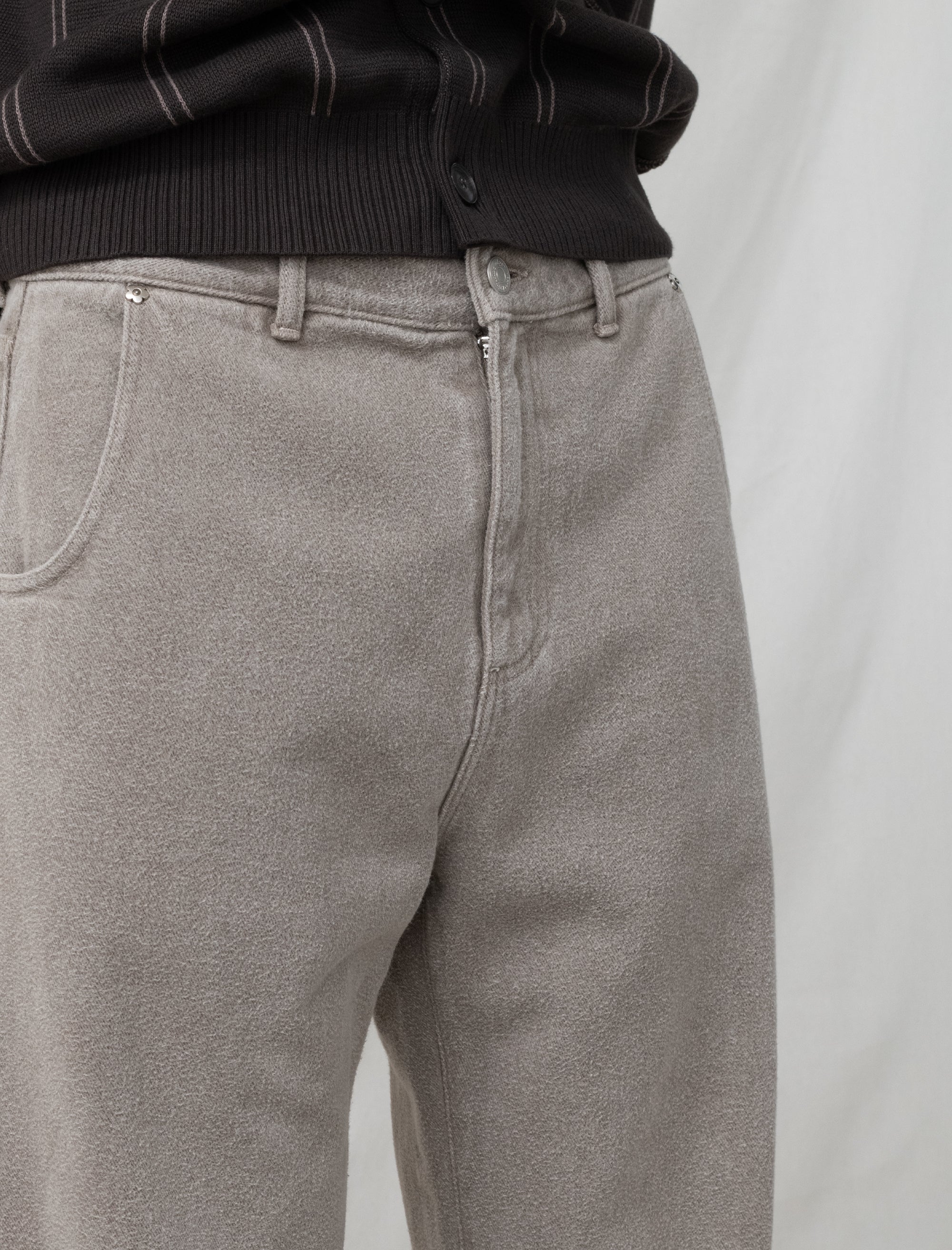 Close-up of gray pants with a black sweater on a light gray background