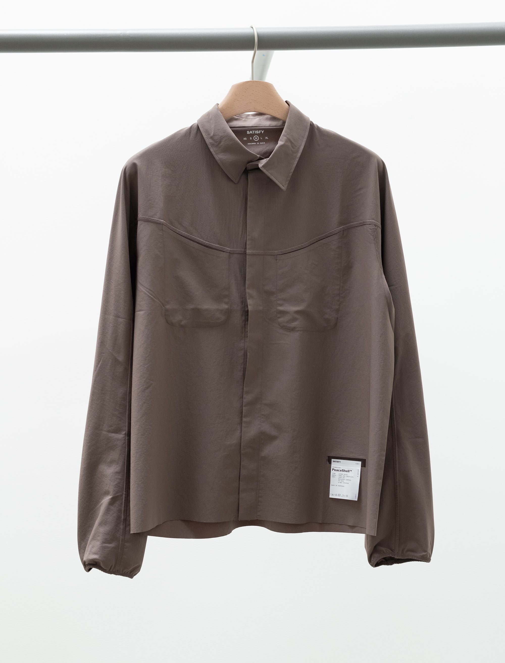 Brown jacket on a hanger against a white background