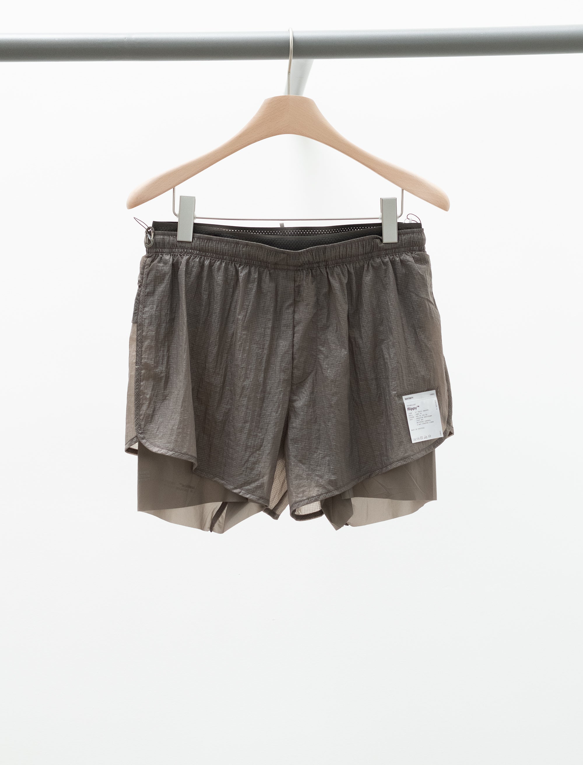 Brown shorts on a hanger against a white background
