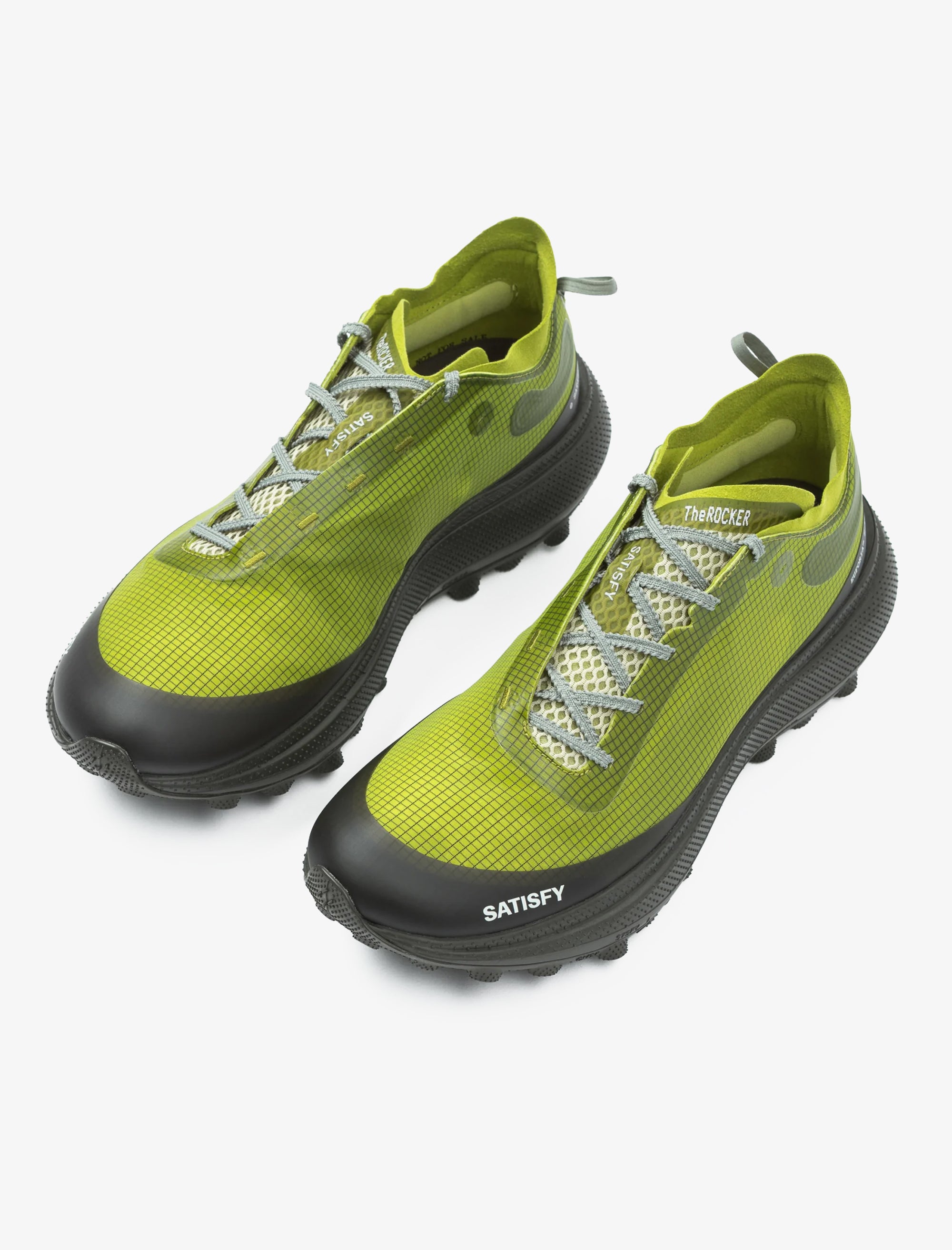 Green and black shoes with 'Satisfy' branding on a white background