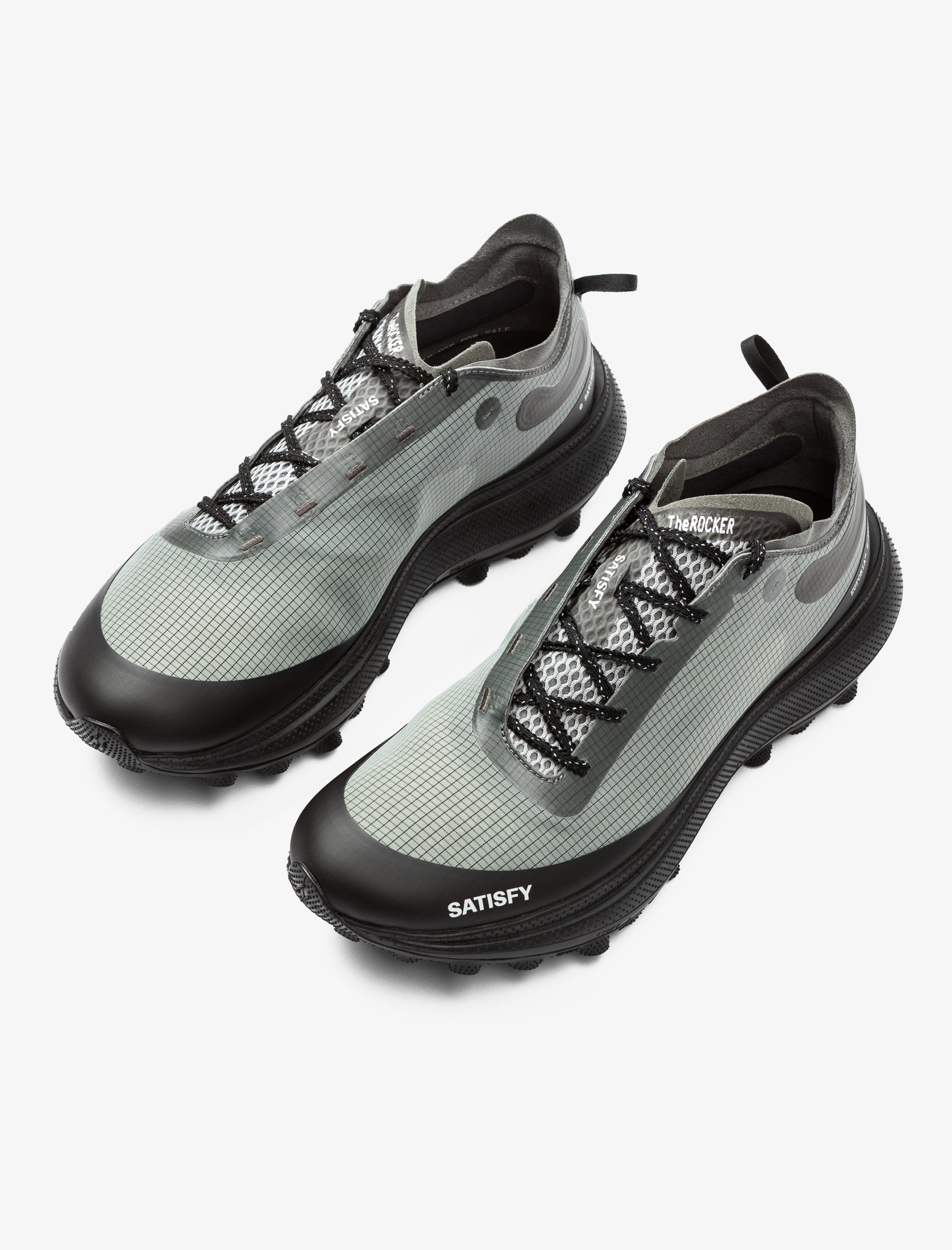 Gray and black sneakers with 'Satisfy' branding on a white background