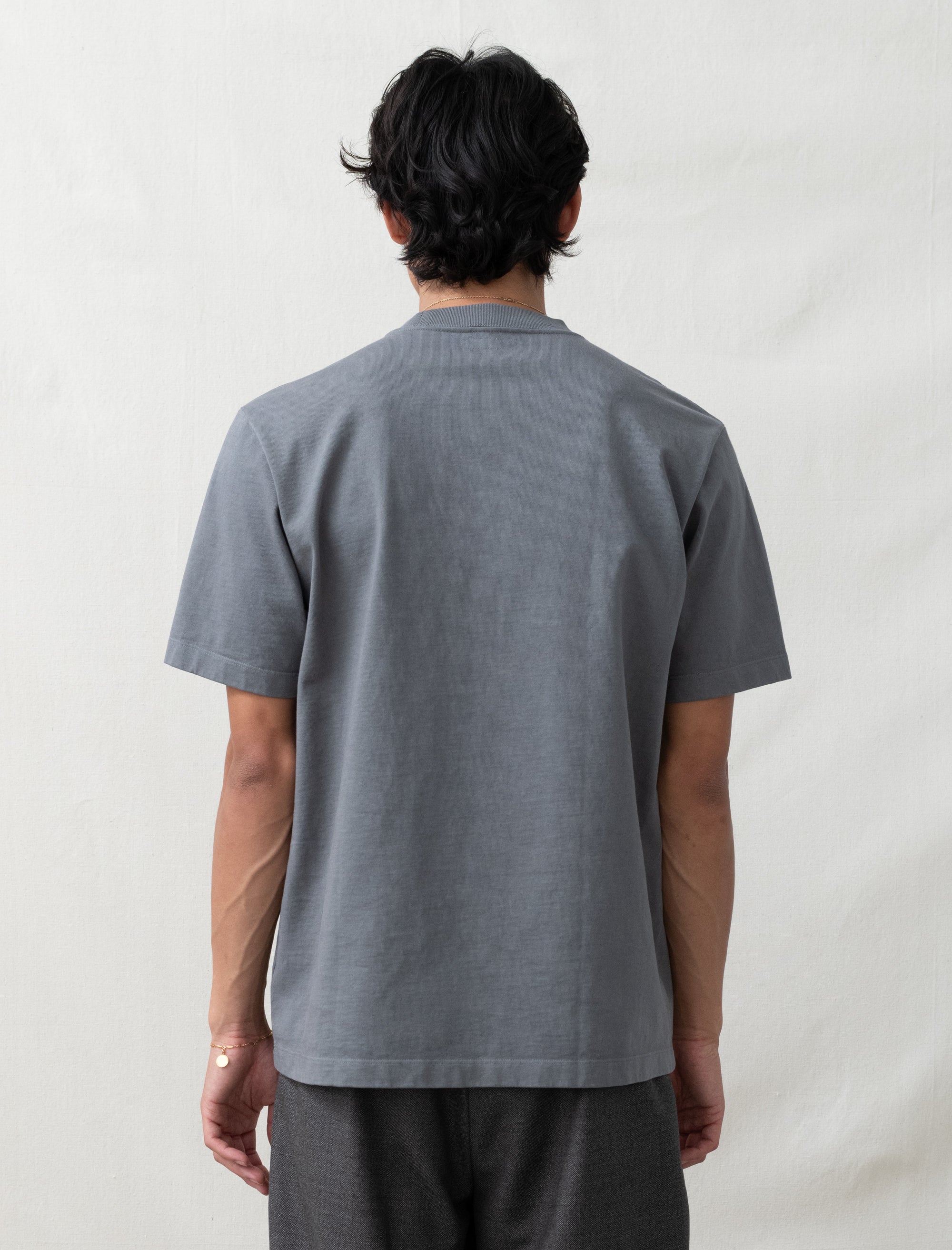 Person wearing a gray polo shirt against a plain background