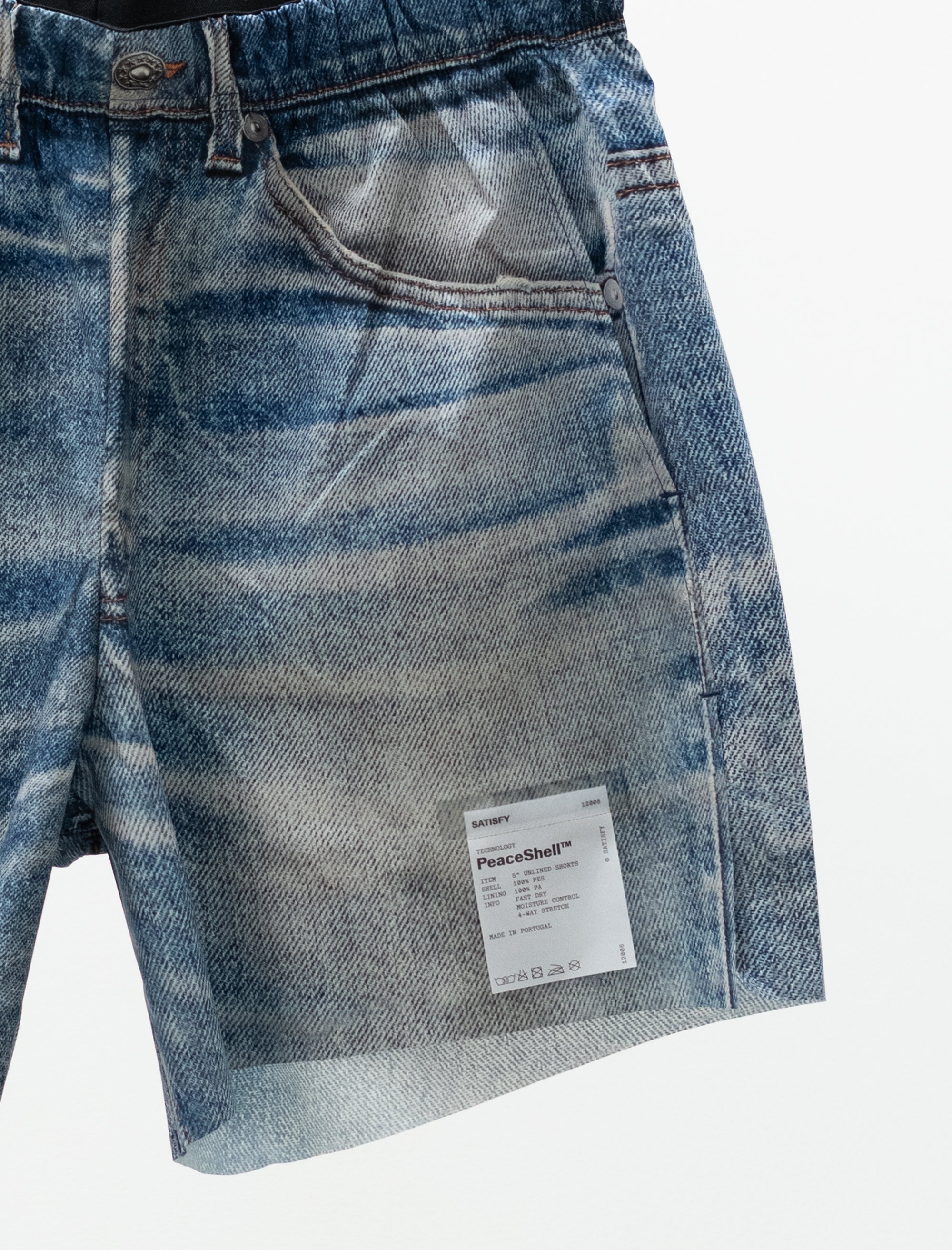 Close-up of a blue denim short with a brand label on a white background