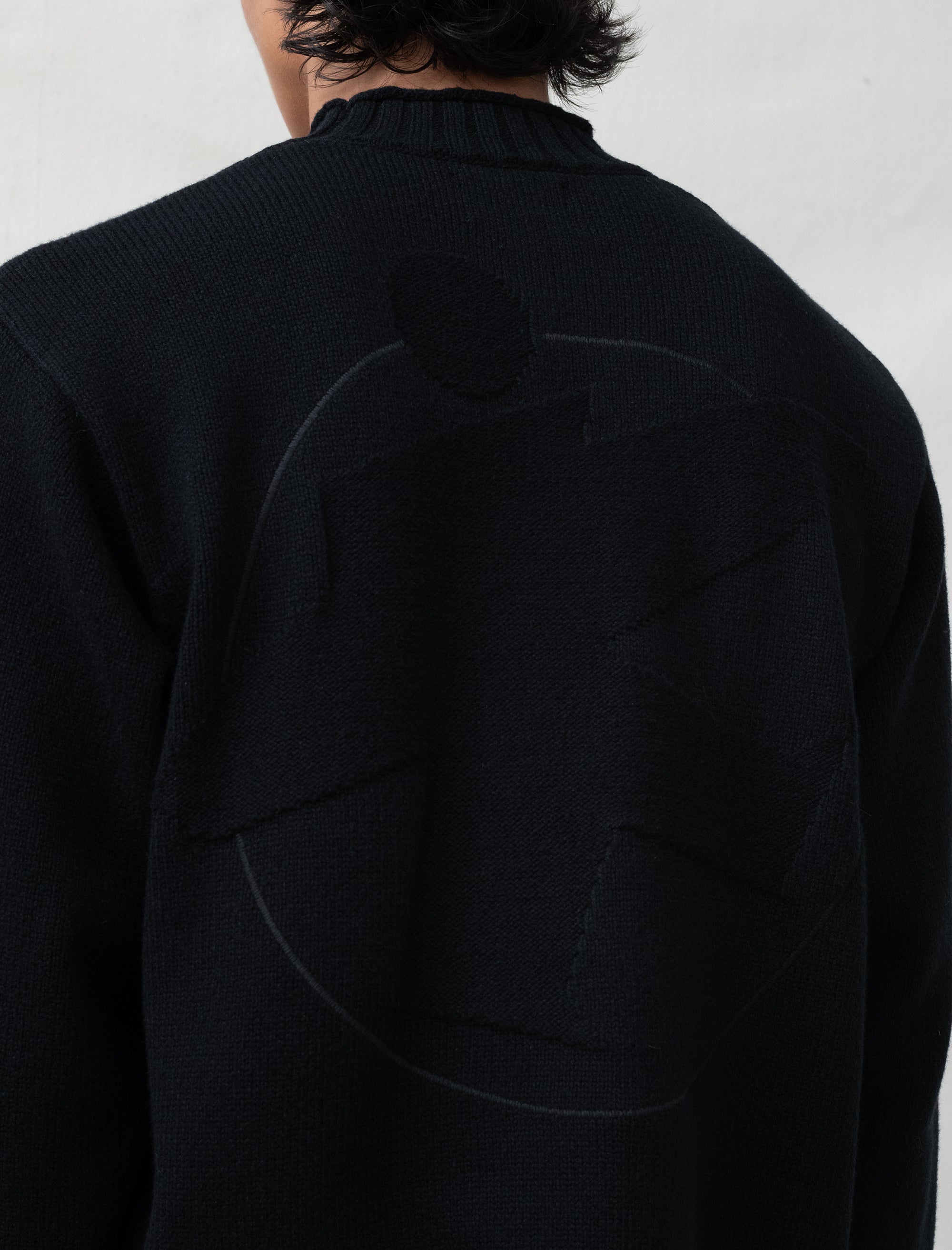 person wearing black sweater in front of white background