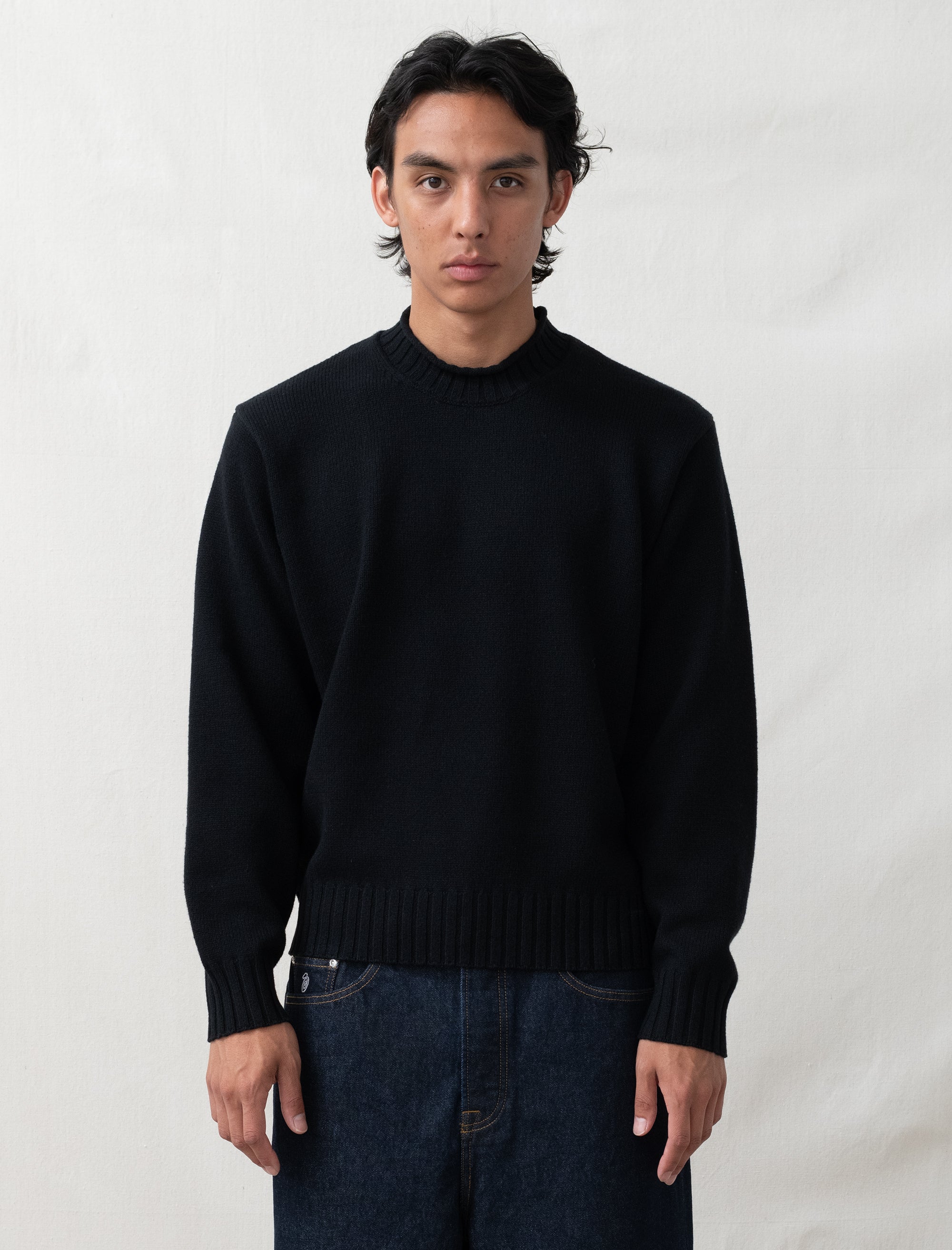 person wearing black sweater in front of white background