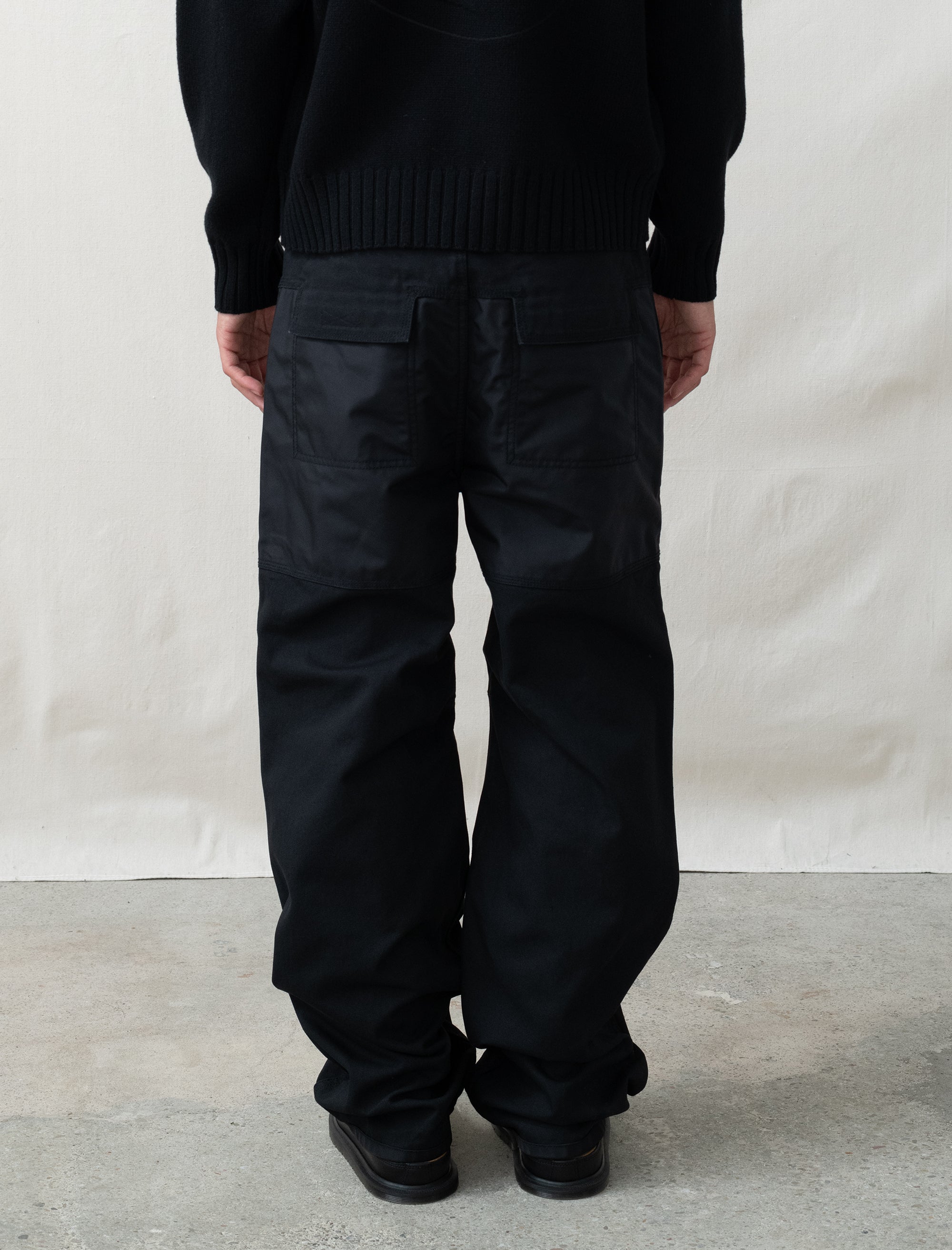 person wearing black pants in front of white background