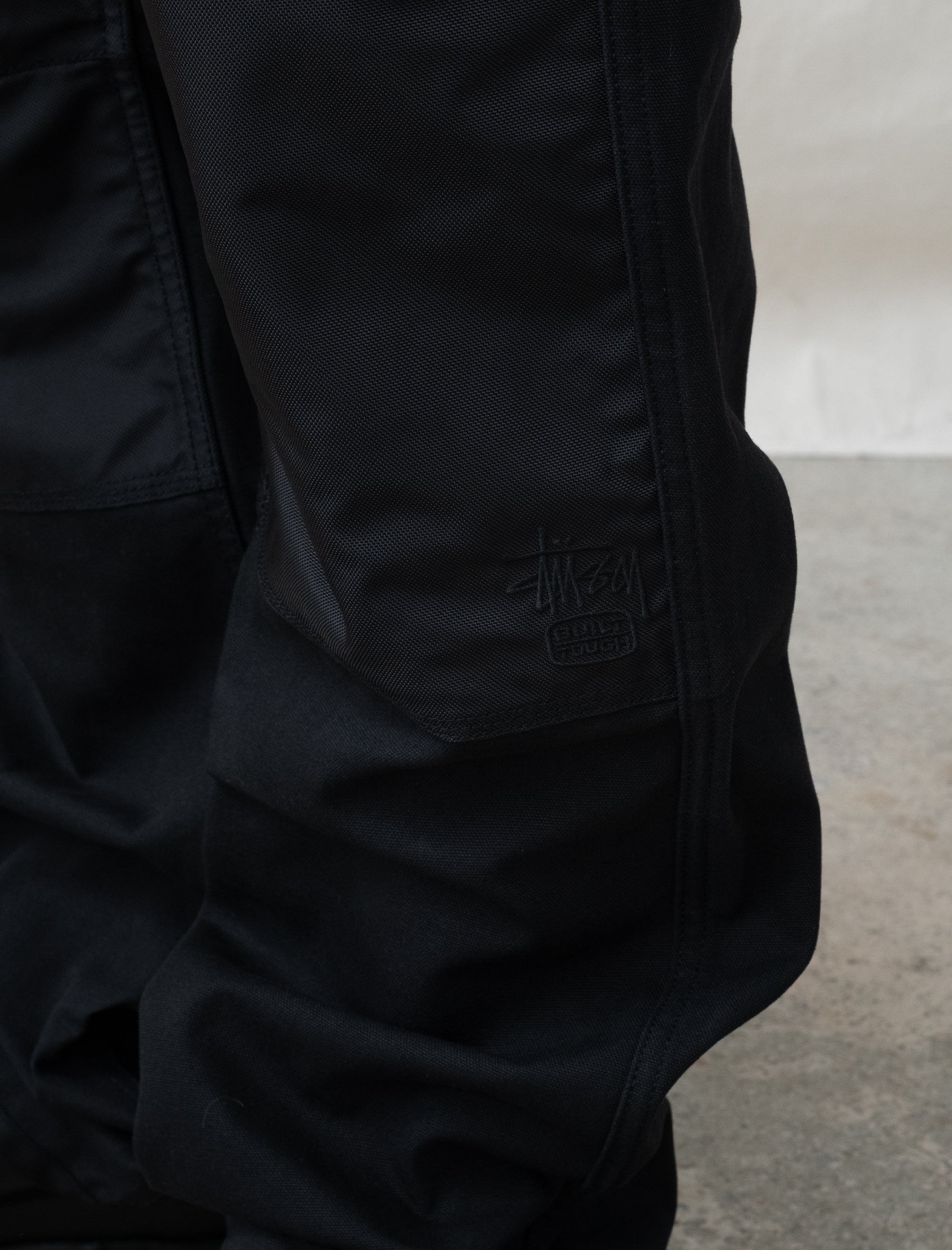 person wearing black pants in front of white background