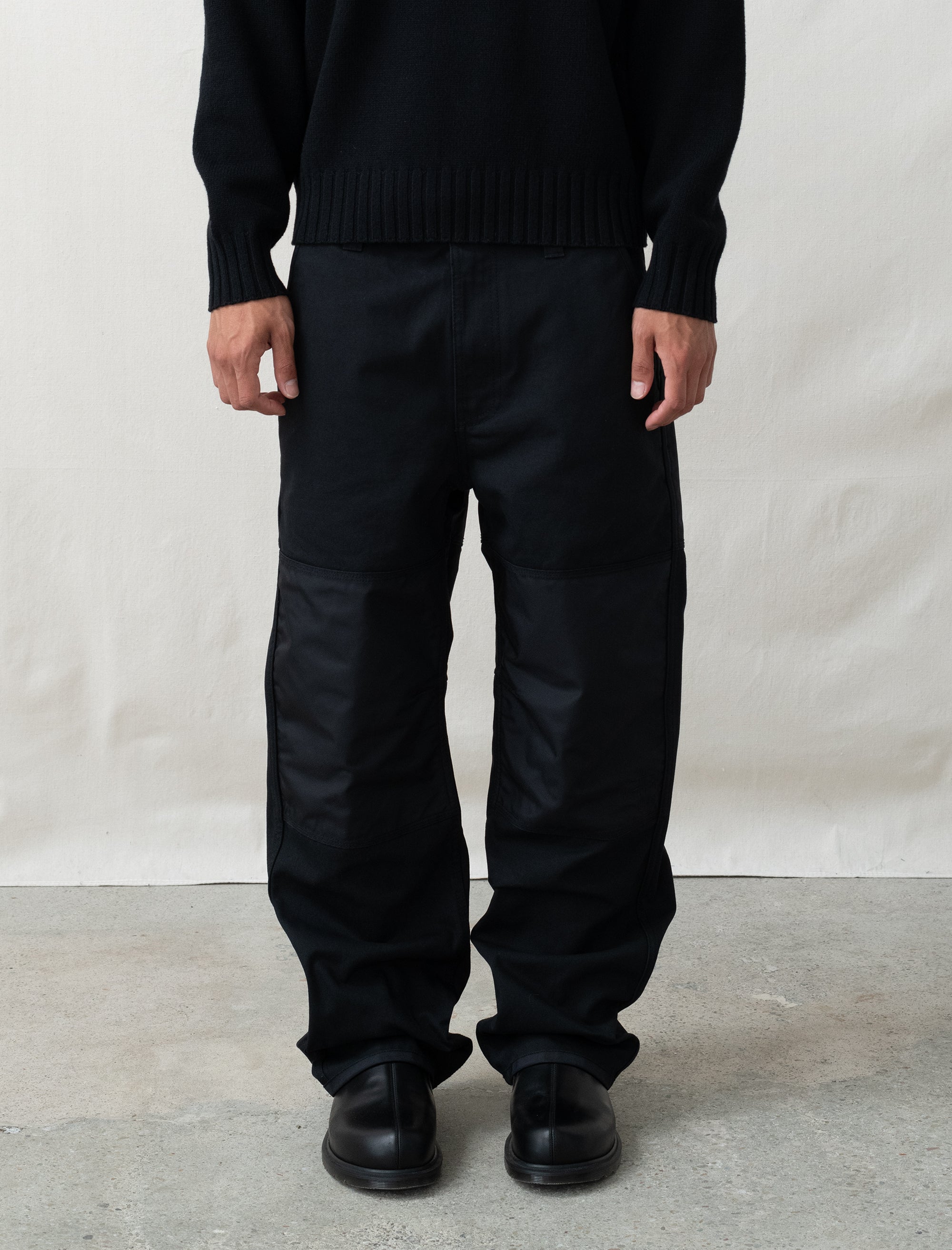 person wearing black pants in front of white background