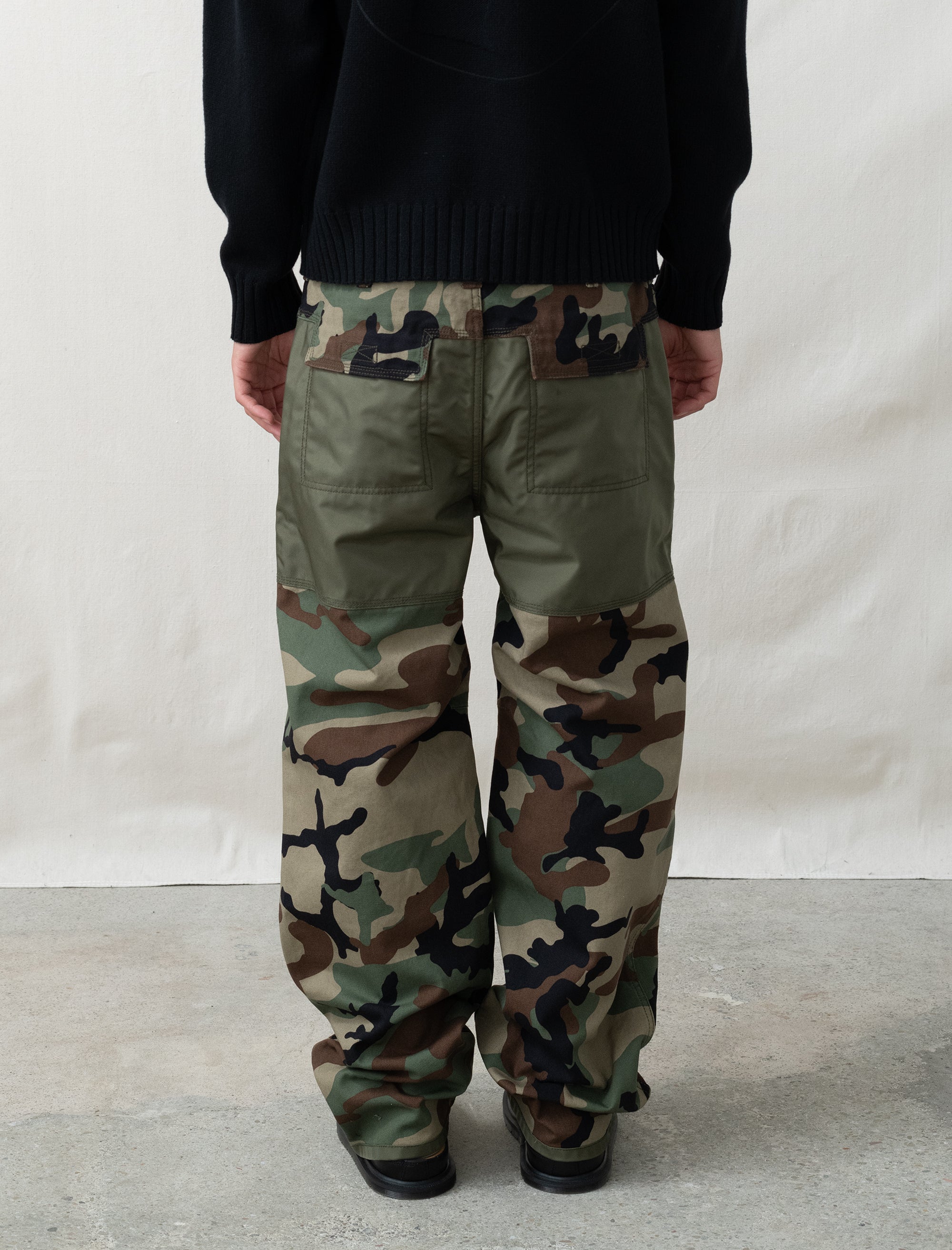 person wearing camo paints in front of white background