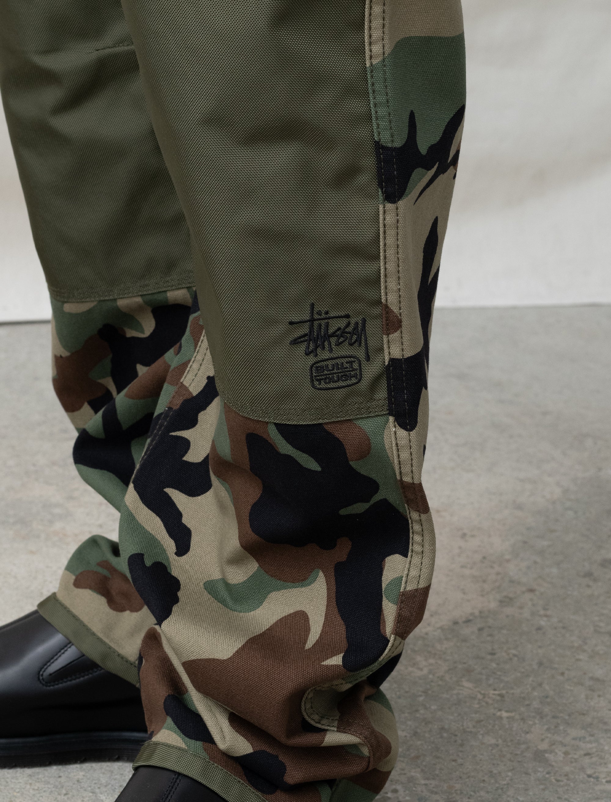 person wearing camo paints in front of white background