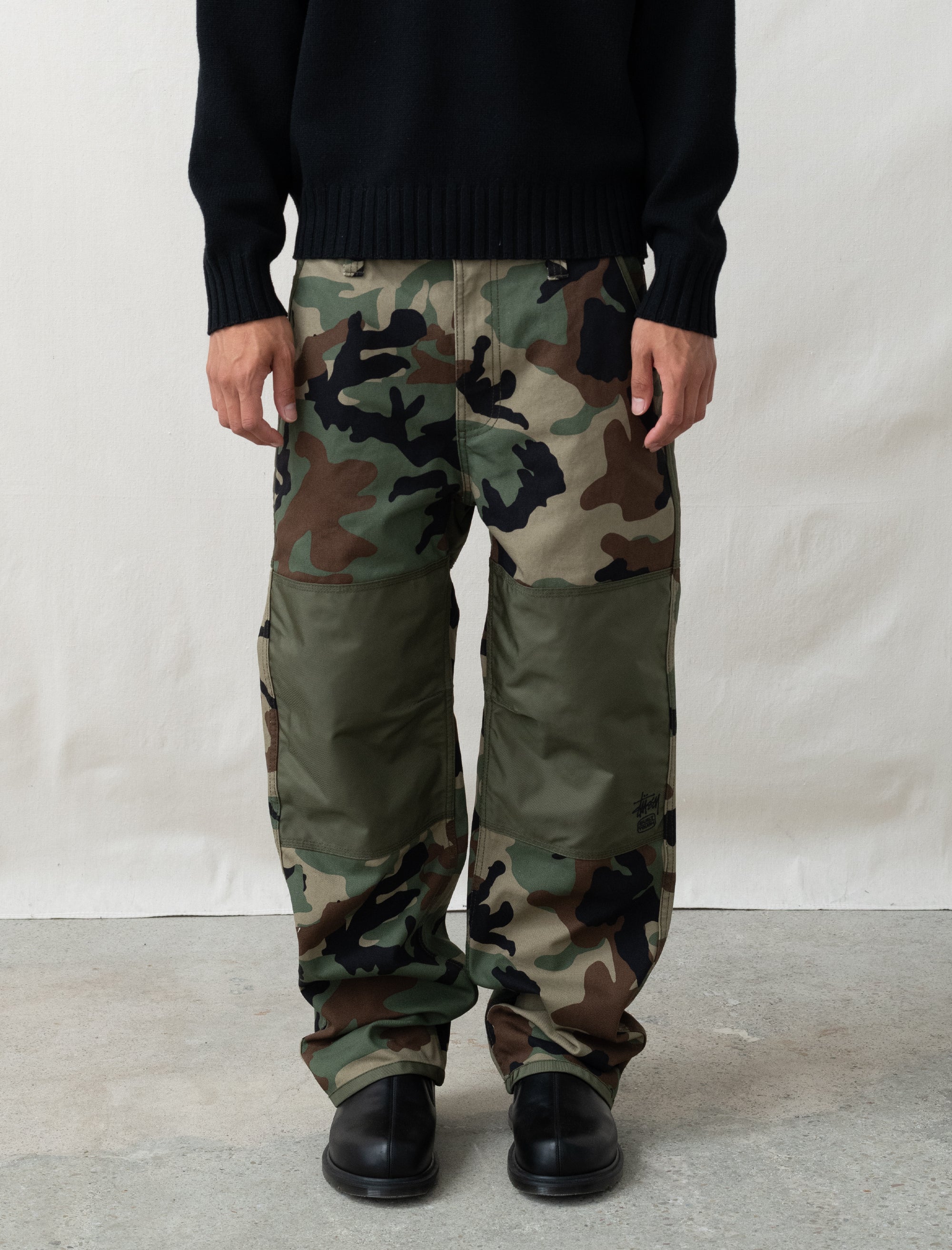 person wearing camo paints in front of white background