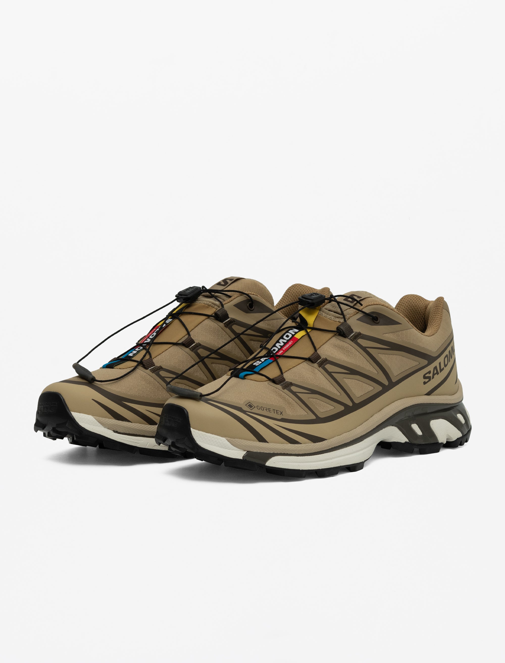 Pair of beige hiking shoes with brand logo on a white background